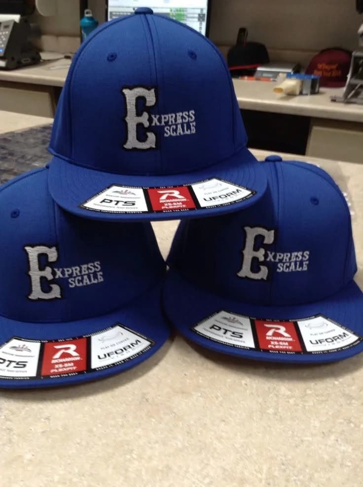 Matching embroidered company caps with custom logo, produced by Inca Threads for a Sacramento business team.